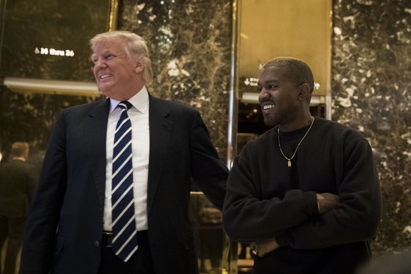 NEW YORK, NY - DECEMBER 13: (L to R) President-elect Donald Trump and Kanye West stand together in the lobby at Trump Tower, December 13, 2016 in New York City. President-elect Donald Trump and his tr ...