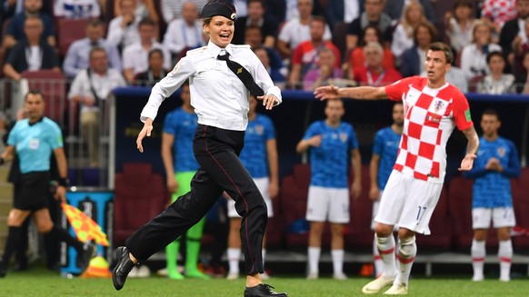 Die Aktivisten waren in der 52. Minute des Finalspiels zwischen Frankreich und Kroatien auf das Spielfeld gerannt. Sie trugen dabei falsche Polizei-Uniformen. Ordnungskräfte stoppten sie und führten sie ab.
