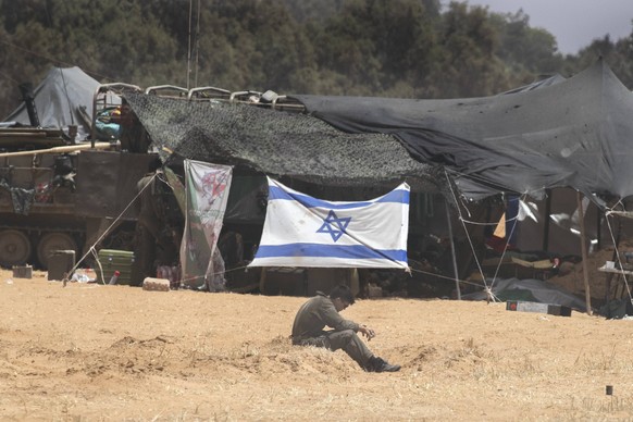 News Bilder des Tages An Israeli soldier sits near tents and armor vehicles in a front line staging area inside southern Israel on Wednesday, May 29, 2024.Israel reported the death of three soldiers k ...