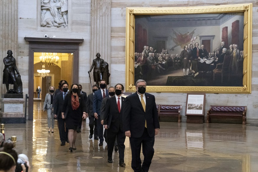 Acting Sergeant at Arms Timothy Blodgett, right, leads Rep. Jamie Raskin, D-Md., second from right, the lead Democratic House impeachment manager, and other impeachment managers, through the Rotunda t ...