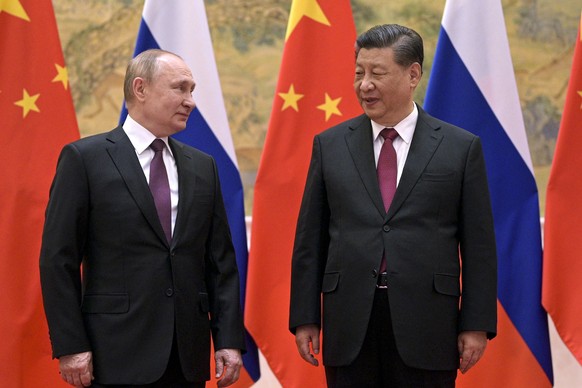 FILE - Chinese President Xi Jinping, right, and Russian President Vladimir Putin talk to each other during their meeting in Beijing, China, on Feb. 4, 2022. By ending 77 years of almost uninterrupted  ...