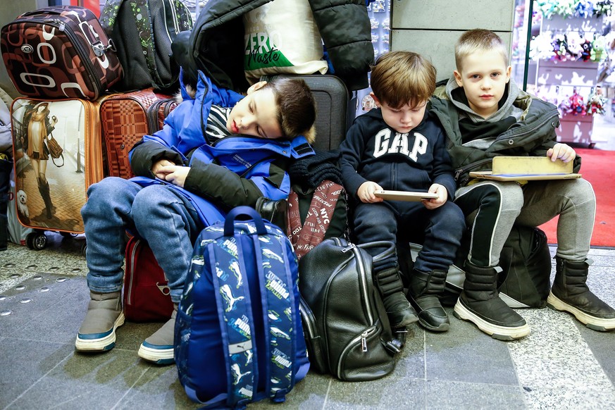 09.03.2022, Polen, Krakau: Ukrainische Fl�chtlingsjungen ruhen sich auf ihrem Gep�ck aus, nachdem sie am Hauptbahnhof in Krakau angekommen sind, da bereits mehr als eine Million Menschen aus der Ukrai ...