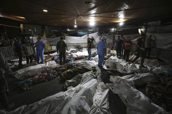 FILE - Bodies of Palestinians killed by an explosion at the Ahli Arab hospital are gathered in the front yard of the al-Shifa hospital, in Gaza City, central Gaza Strip, Tuesday, Oct. 17, 2023. As the ...