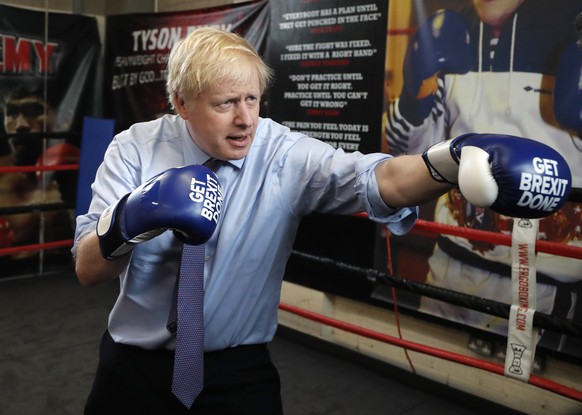 FILE - In this Tuesday, Nov. 19, 2019 file photo Britain's Prime Minister Boris Johnson poses for a photo wearing boxing gloves during a stop in his General Election Campaign trail at Jimmy Egan's Box ...