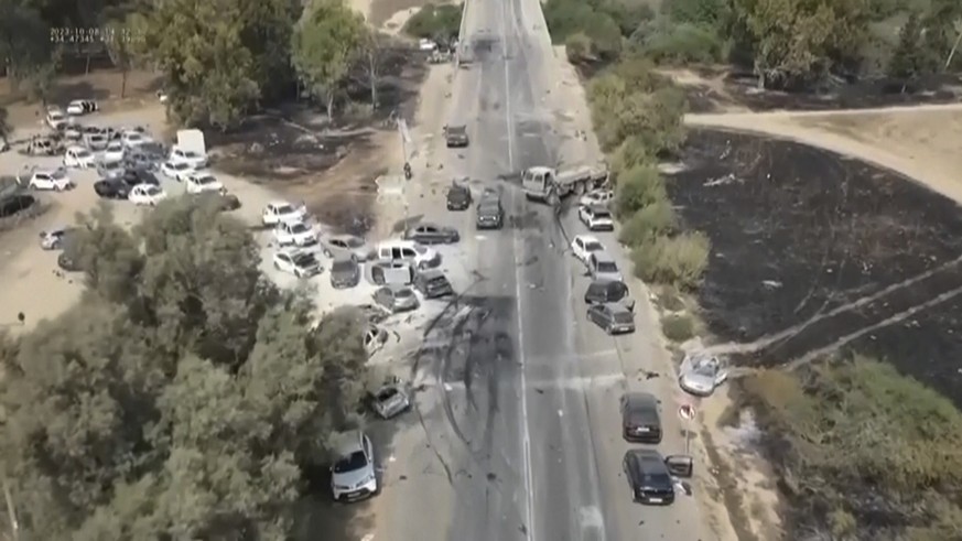 This image from video provided by South First Responders shows charred and damaged cars along a desert road after an attack by Hamas militants at the Tribe of Nova Trance music festival near Kibbutz R ...