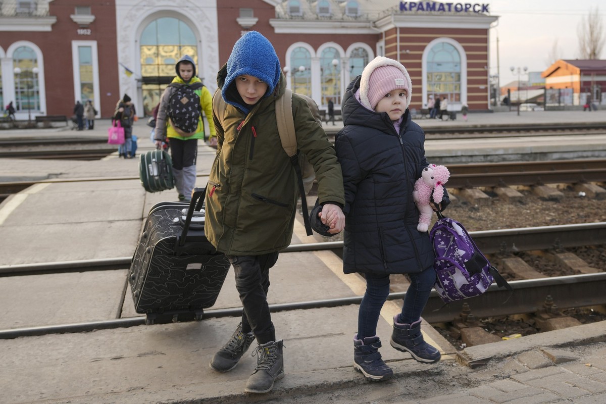 Children hold hands as they arrive to board a Kyiv bound train, on a platform in Kramatorsk, the Donetsk region, eastern Ukraine, Thursday, Feb. 24, 2022. (AP Photo/Vadim Ghirda)