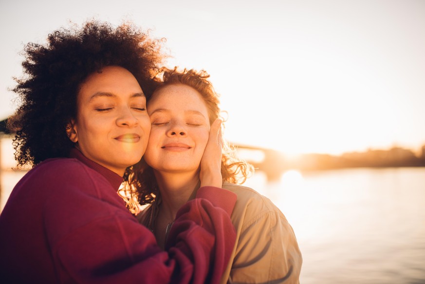 Portrait of two girls hugging and enjoying the sunset together.