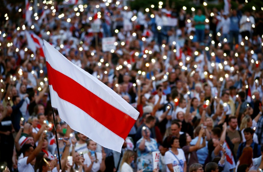 A historical white-red-white flag of Belarus is seen as people attend an opposition demonstration to protest against presidential election results, in Minsk, Belarus August 18, 2020. REUTERS/Vasily Fe ...