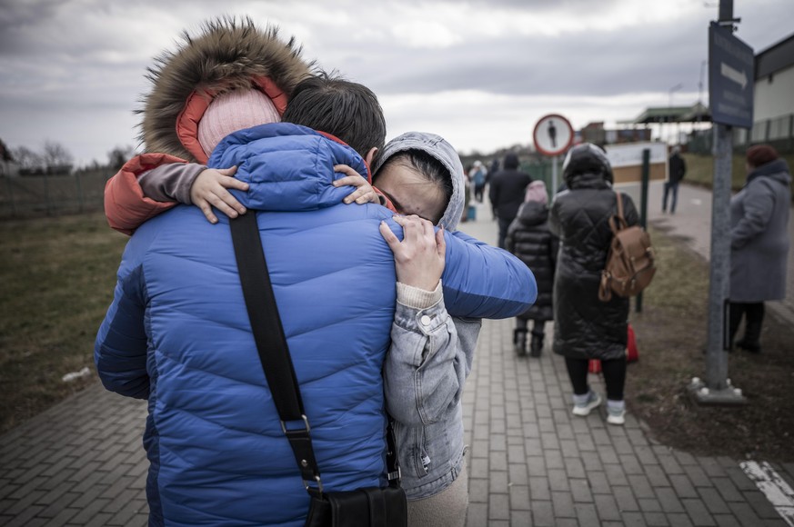 Ein Geflüchteter aus der Ukraine hat Polen erreicht. Nach dem Grenzübertritt umarmt er seine Tochter und seine Enkelin.