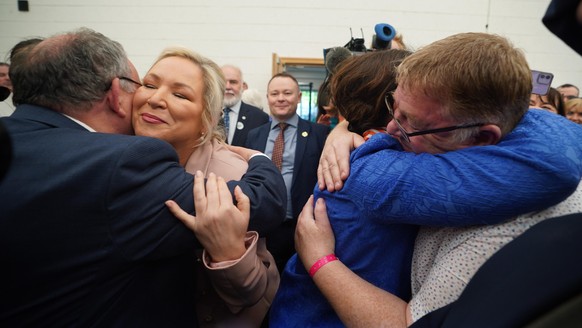 2022 NI Assembly election. Sinn Fein leader Mary Lou McDonald (right) and Michelle O&#039;Neill (left) are hugged by wellwishers as they arrive at the Northern Ireland Assembly Election count centre a ...