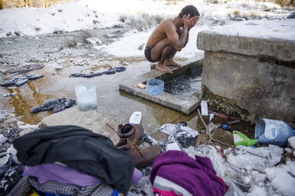A migrant from Pakistan Hagiaz Abdulrehman cleans himself in a stream at the Lipa migrant camp, near Bihac, Bosnia and Herzegovina, on January 15, 2021. The water in the tanks froze this morning becau ...