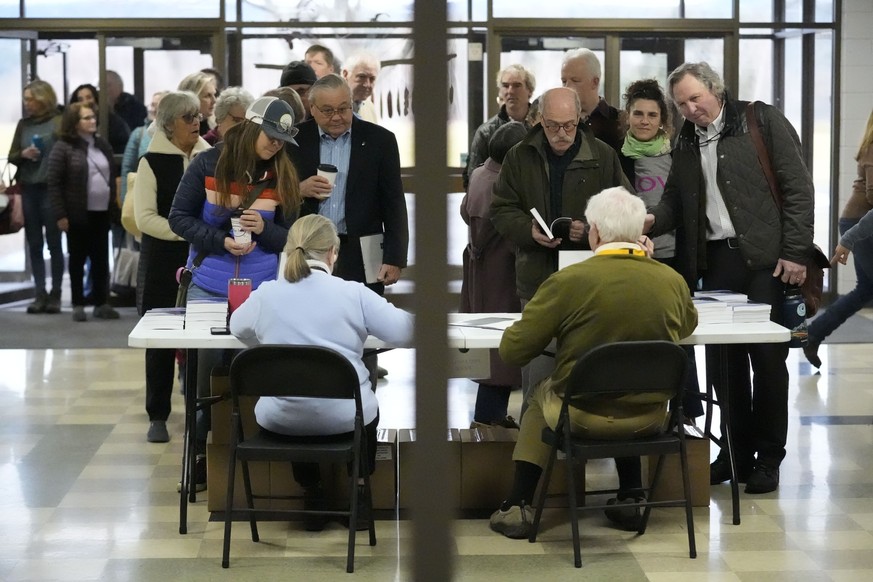 05.03.2024, USA, Stowe: Menschen warten darauf, sich vor einer Bürgerversammlung und der Stimmabgabe bei den Vorwahlen einzutragen. Am Super Tuesday finden in 16 Staaten und einem Territorium Wahlen s ...