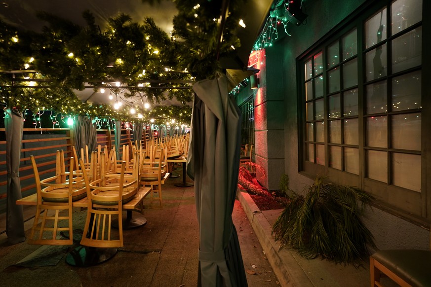 FILE - In this Monday, Dec. 7, 2020, file photo, chairs are stacked on tables in the closed outdoor dining area of a restaurant in Rowland Heights, Calif. The vast region of Southern California went i ...