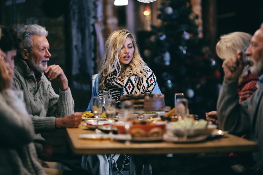 Family having dinner outdoors in their back yard.