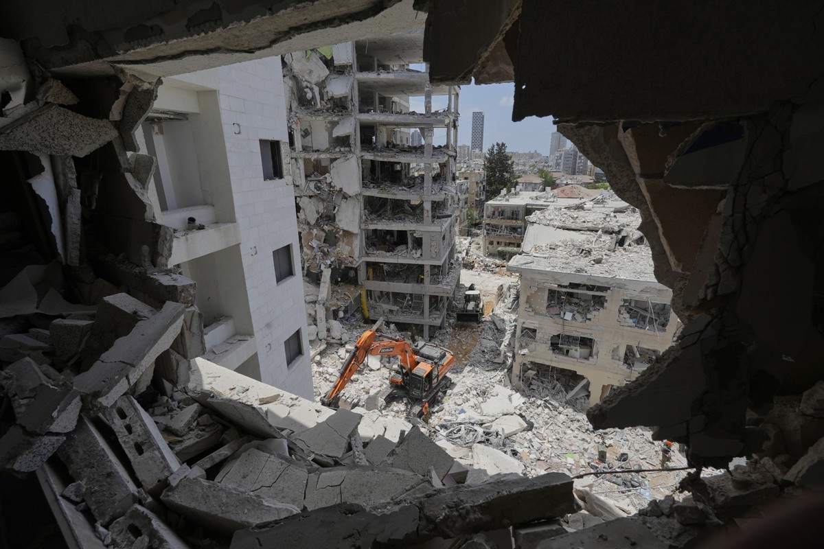 15.06.2025, Israel, Bat Yam: Israelische Rettungskräfte suchen nach Überlebenden in den Trümmern von Wohnhäusern, die durch einen iranischen Raketenangriff in Bat Yam, Zentralisrael, zerstört wurden.  ...