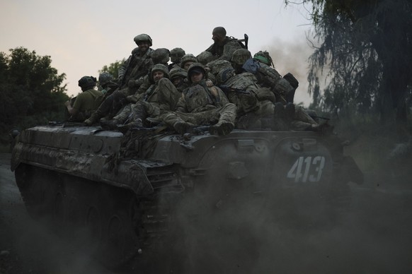 29.06.2023, Ukraine, Bachmut: Ukrainische Soldaten fahren oben auf einem APC an der Frontlinie in der Nähe von Bachmut. Foto: Alex Babenko/AP +++ dpa-Bildfunk +++