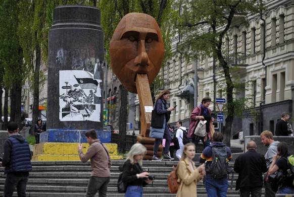 Menschen fotografieren eine Skulptur in Kiew, die den russischen Präsidenten Wladimir Putin darstellt und den Namen "Shoot yourself" trägt.