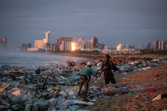 (220413) -- KWAZULU-NATAL, April 13, 2022 (Xinhua) -- People collect trash on a beach after heavy rains in Durban, KwaZulu-Natal Province, South Africa, April 13, 2022. The death toll due to heavy rai ...