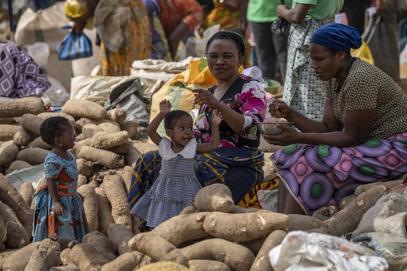 28.02.2023, Nigeria, Abuja: Junge Mädchen stehen bei ihren Müttern, die auf dem zweiwöchentlichen Karmo-Straßenmarkt Gemüse verkaufen. Bei der Präsidentschaftswahl in Nigeria liegt der Kandidat der re ...