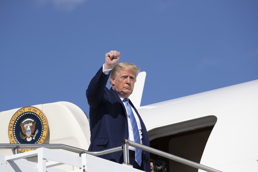 President Donald Trump raises his arm up as he boards Air Force One at Morristown Municipal Airport, Sunday, June 14, 2020, in Morristown, N.J. Trump is returning to Washington. (AP Photo/Alex Brandon ...