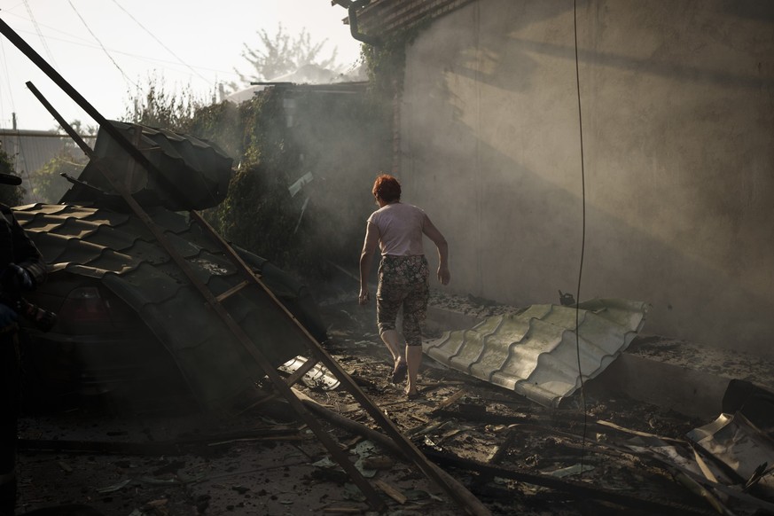 A woman walks outside her burning house after a Russian attack in Kherson, Ukraine, Friday, June 9, 2023. (AP Photo/Felipe Dana)