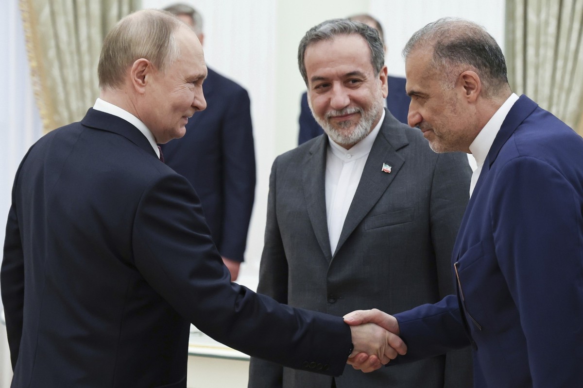 Russian President Vladimir Putin, left, greets Ambassador of Iran to Russia Kazem Jalali, right, and Iranian Foreign Minister Abbas Araghchi, center, prior to their talks at the Kremlin in Moscow, Rus ...