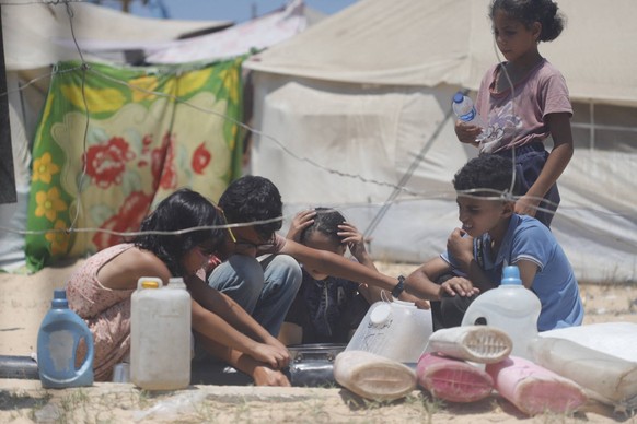 Polio Detected In Sewage Water - Gaza Palestinian children desperately try to collect water on July 20, 2024, west of Khan Yunis, Gaza Strip. Poliovirus has been detected in samples of sewage water in ...