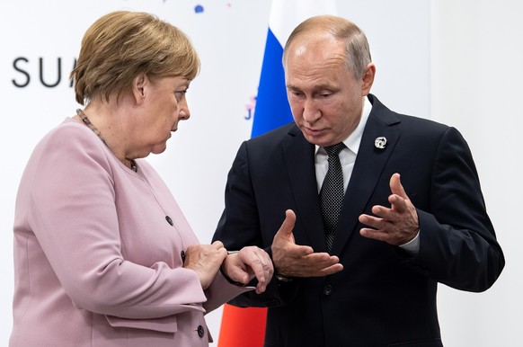 ARCHIV - 29.06.2019, Japan, Osaka: Angela Merkel (CDU), fr�here Bundeskanzlerin, trifft sich am Rande des G20-Gipfels mit dem russischen Pr�sidenten Wladimir Putin. Merkel�hat die Entscheidung fr�here ...