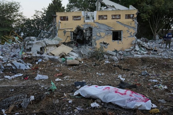 dpatopbilder - 11.10.2023, Israel, Kibbuz Be&#039;eri: Die Leiche eines getöteten Terroristen der Hamas liegt im Kibbuz Be&#039;eri in einem Leichensack. Foto: Ohad Zwigenberg/AP/dpa +++ dpa-Bildfunk  ...