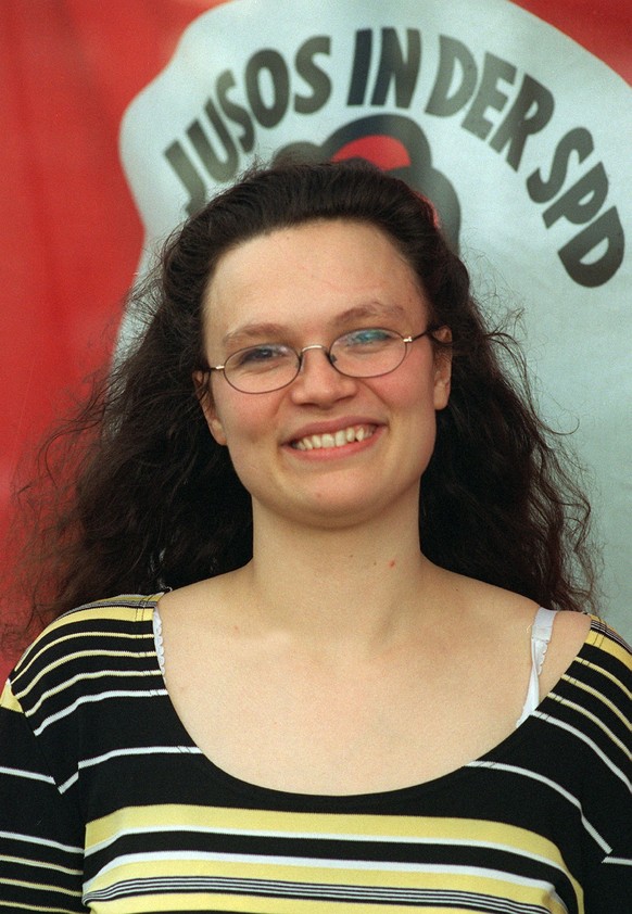 ARCHIV - 10.05.1997, Berlin: Lachend steht Andrea Nahles, damals Bundesvorsitzende der Arbeitsgemeinschaft der Jungsozialistinnen und Jungsozialisten in der SPD (JUSOS), vor einem Plakat der Jungsozia ...