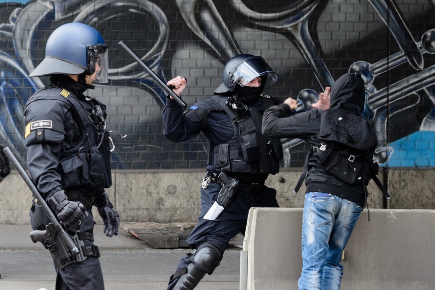 Ein Polizeibeamter setzt am 01.05.2017 in Halle/Saale nach dem Ende eines rechten Aufmarsches gegen einen linken Gegendemonstranten seinen Schlagstock ein. Foto: Jens Schlueter/dpa-Zentralbild/dpa | V ...