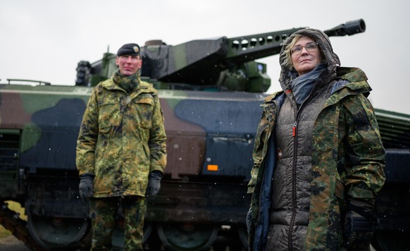 Christine Lambrecht (r, SPD), Verteidigungsministerin, lässt sich bei ihrem Besuch der Panzerlehrbrigade 9 einen Schützenpanzer vom Typ Puma erklären.