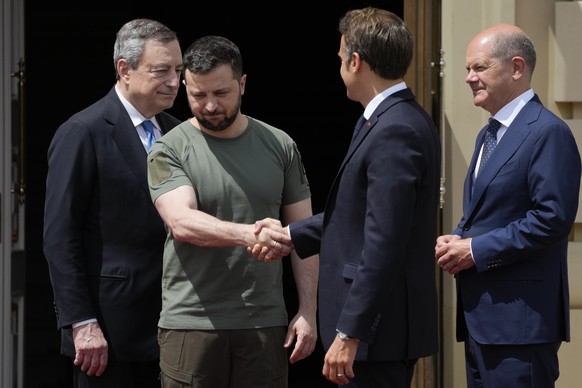 FILE - Ukrainian President Volodymyr Zelenskyy, second left, shake hands with French President Emmanuel Macron, as they are flanked by Italian Prime Minister Mario Draghi, left, and German Chancellor  ...