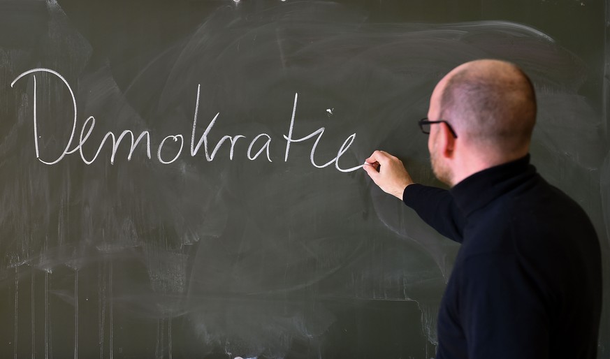 11.04.2019, Berlin: Andreas Steiner, Schulleiter der Fichtenberg-Oberschule im Berliner Steglitz, schreibt an der Tafel das Wort &quot;Demokratie&quot;. (zu dpa-Story &quot;Hakenkreuz im Klassenzimmer ...