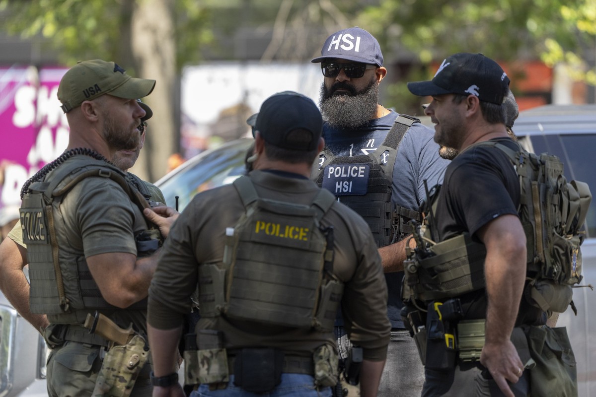 Federal officers speak as they stand at a checkpoint operated by the Metropolitan Police Department and federal agencies, including officers from Immigration and Customs Enforcement (ICE) and Homeland ...