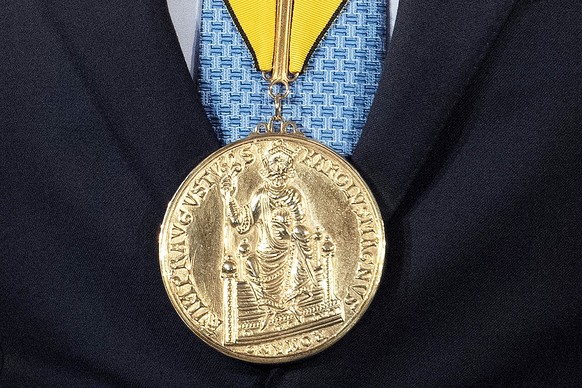 ARCHIV - 02.10.2021, Nordrhein-Westfalen, Aachen: Die Karlspreis-Medaille hängt während der Verleihung am Hals von Klaus Iohannis, Präsident von Rumänien. Der Karlspreis 2023 geht an den ukrainischen  ...