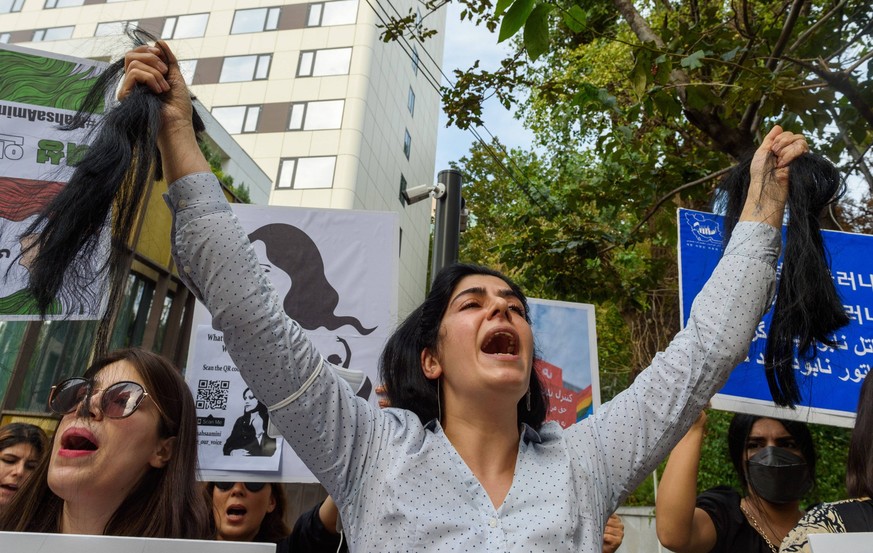September 28, 2022, Seoul, South Korea: An Iranian female protester chants slogans as she holds pieces of her cut hair during a rally against the death of Iranian Mahsa Amini outside the Embassy of th ...