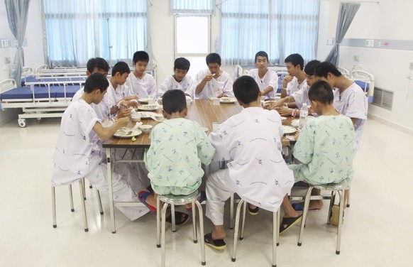 In this photo released by Thailand's Ministry of Health and the Chiang Rai Prachanukroh Hospital some of the rescued soccer team members eat a meal together in a hospital, Sunday, July 15, 2018, in Ch ...
