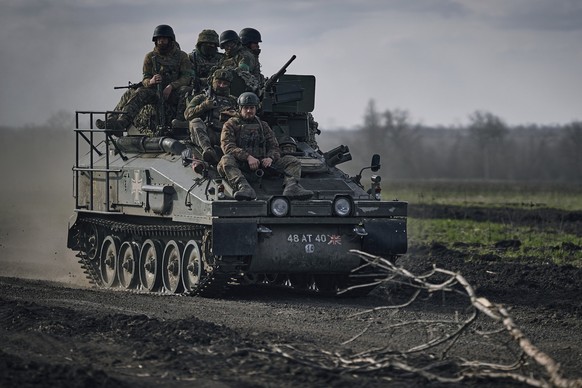 26.03.2023, Ukraine, Bachmut: Ukrainische Soldaten fahren auf einem APC an der Frontlinie in Bachmut, Region Donezk, Ukraine. Foto: Libkos/AP/dpa +++ dpa-Bildfunk +++