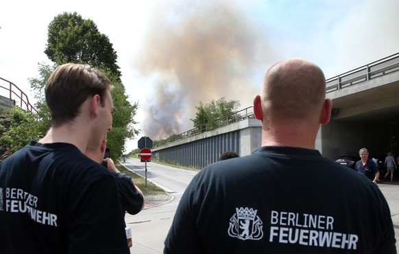 04.08.2022, Berlin: Feuerwehrleute beobachten eine Rauchs�ule eines Waldbrandes im Grunewald. Durch einen Waldbrand im Grunewald, der nach Angaben der Polizei auf dem Sprengplatz ausgel�st wurde, sind ...