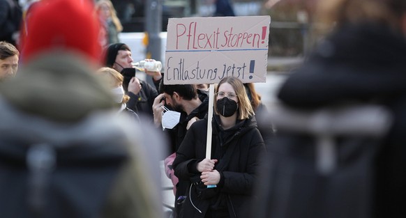 Eine Frau aus dem Gesundheitswesen demonstriert in Hamburg für bessere Arbeitsbedingungen.