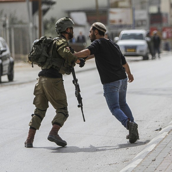 February 27, 2023, Nablus, Palestine: Israeli soldiers stand guard while Jewish settler protest against the Palestinians in the town of Hawara, south of the city of Nablus, in the occupied West Bank.  ...