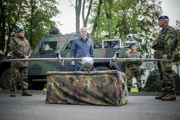 23.10.2023, Nordrhein-Westfalen, Köln: Bundeskanzler Olaf Scholz (SPD) schaut sich beim Besuch der Fähigkeitsdemonstration der Territorialen Verfügungsgruppe auf dem Militärflughafen Köln-Wahn eine Dr ...