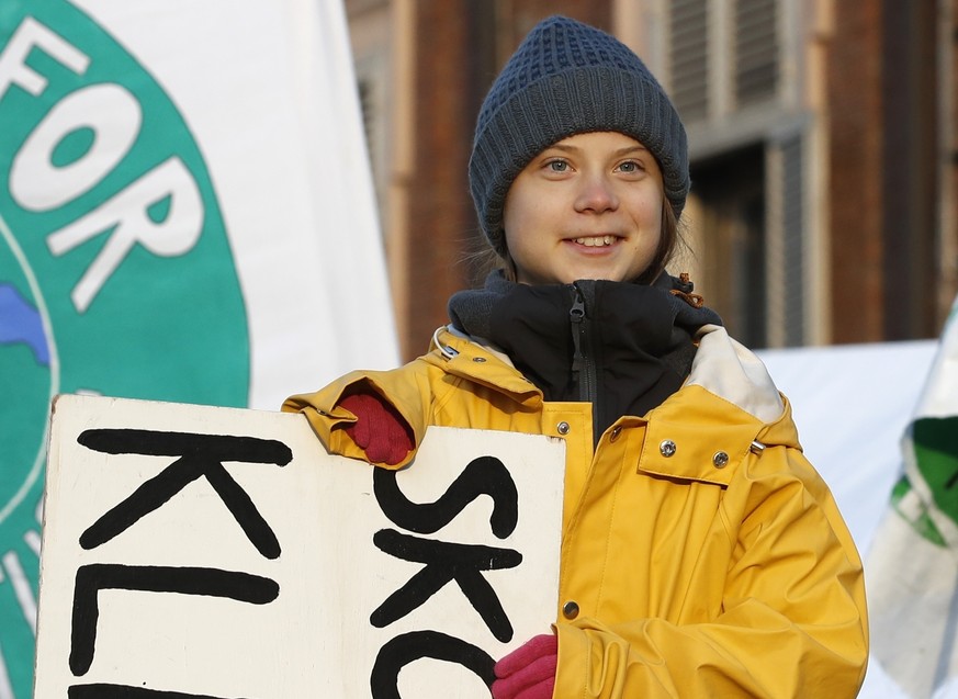 Swedish environmental activist Greta Thunberg holds a sign with writing reading in Swedish &quot;School strike for the climate&quot; as she attends a climate march, in Turin, Italy, Friday. Dec. 13, 2 ...
