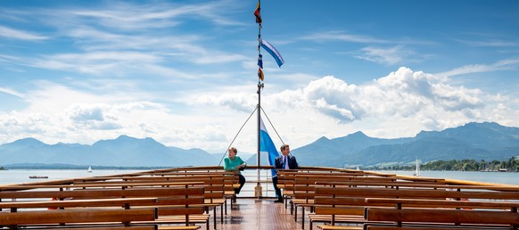 German Chancellor Angela Merkel and Bavarian State Premier Markus Soeder are on their way by boat to attend a Bavarian state cabinet meeting at Herrenchiemsee Island, Germany, July 14, 2020. Peter Kne ...
