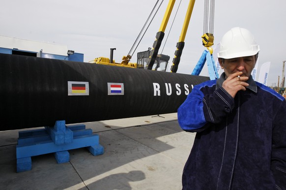 FILE - In this Friday, April 9, 2010 file photo a Russian construction worker smokes in Portovaya Bay some 170 kms (106 miles) north-west from St. Petersburg, Russia, during a ceremony marking the sta ...