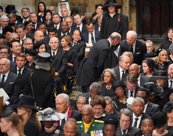 US President Joe Biden takes his seat with wife Jill Biden, other heads of state and dignitaries, including French President Emmanuel Macron at the State Funeral of Queen Elizabeth II, held at Westmin ...