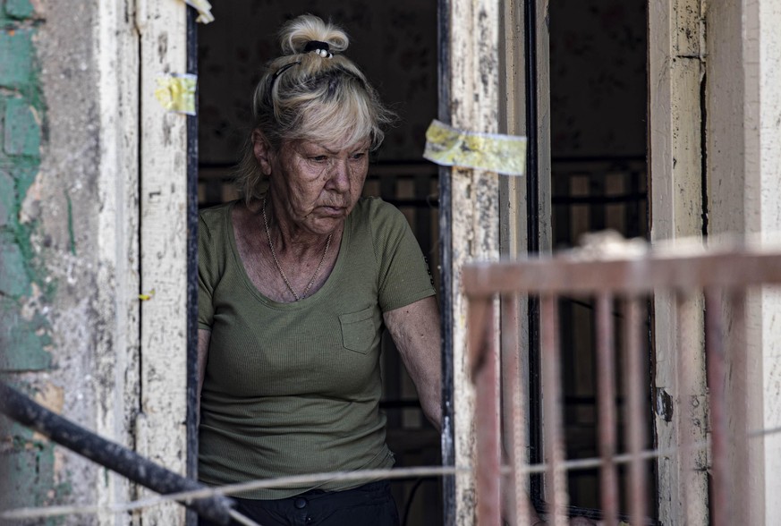 Charkiw: Eine Bewohnerin betrachtet die Ruinen ihres Wohnhauses nach russischem Beschuss.