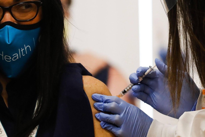 December 16, 2020, USA: Dr. Marina Del Rios, from the University of Illinois health system, reacts as she receives Chicago s first COVID-19 vaccination from Dr. Nikhila Juvvadi on Dec. 15, 2020. USA - ...