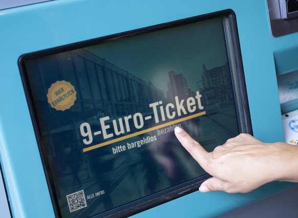 ARCHIV - 01.08.2022, Hessen, Frankfurt/Main: Eine Frau zieht sich an einem Fahrschein-Automaten ein 9-Euro-Ticket. Millionen Menschen haben sich ein 9-Euro-Ticket gekauft. (zu dpa &quot;Studien:�9-Eur ...